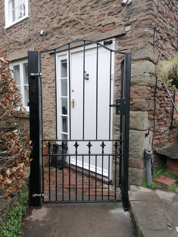 Tall metal gate with a nice wrought iron finish