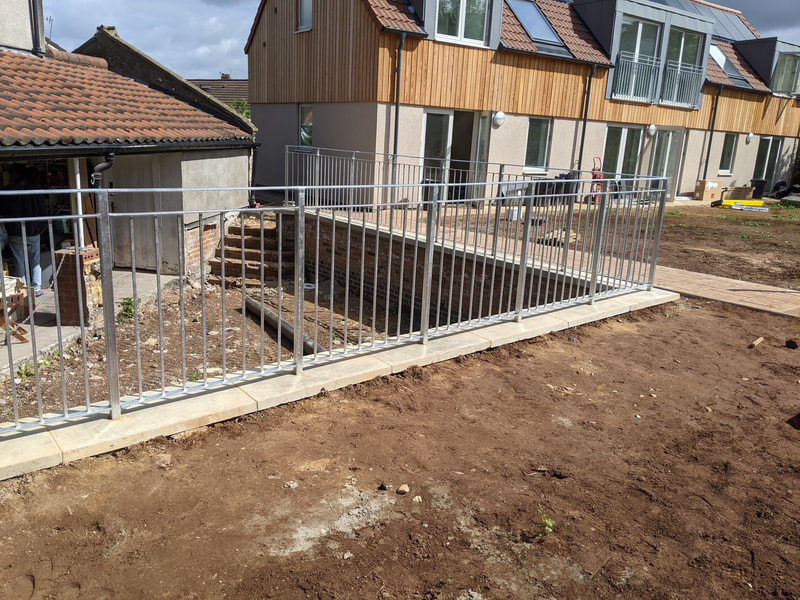 Galvanized steel railings atop this retaining wall in Knowle, Bristol